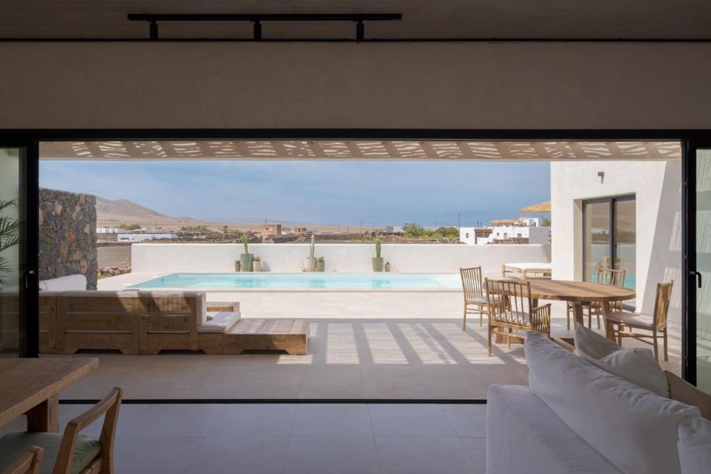 a patio with a pool and a table and chairs at Casa Victoria El Roque in Roque