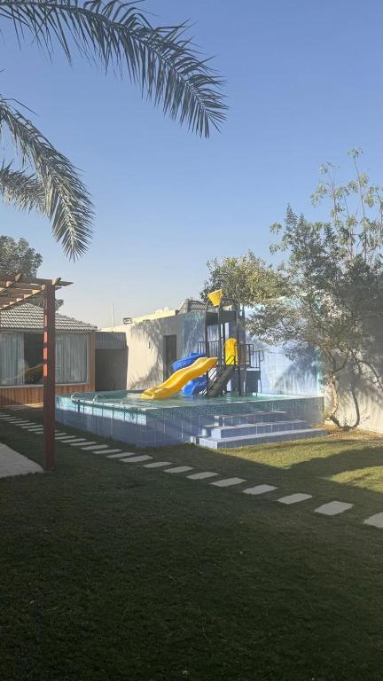 a park with a playground with a yellow slide at شاليهات وقت الفرح in Riyadh