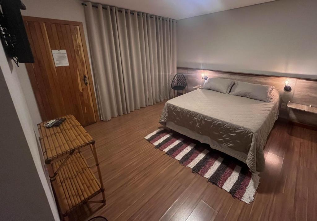 a bedroom with a bed and a wooden floor at Pousada Vento Sul in Chapada dos Guimarães