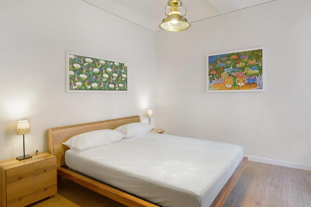 a bedroom with a bed and two pictures on the wall at La Casa Del Marinaio in Rapallo
