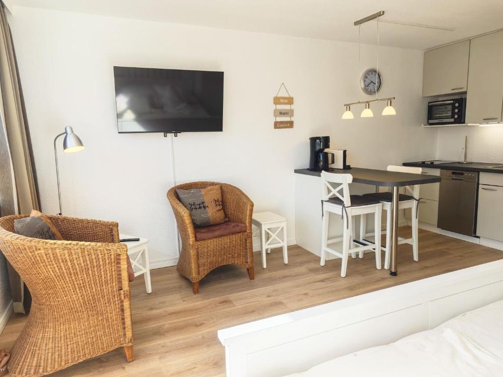 a kitchen and living room with a table and chairs at Strand Sand Sylt in Westerland