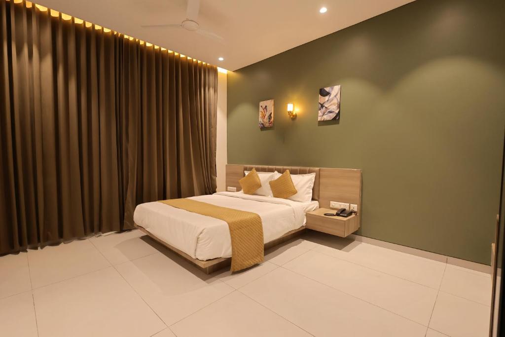 a bedroom with a bed and a large window at Hotel Pune Pride, Baner in Pune