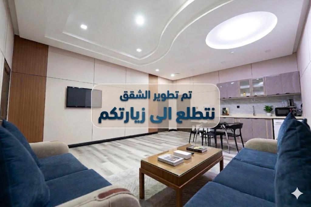 a living room with a blue couch and a table at Dar Hashim Serviced Apartments Al Morouj - Economic in Riyadh