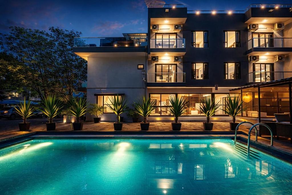 a swimming pool in front of a building at night at Taaffeite Hotels And Resorts in Lonavala