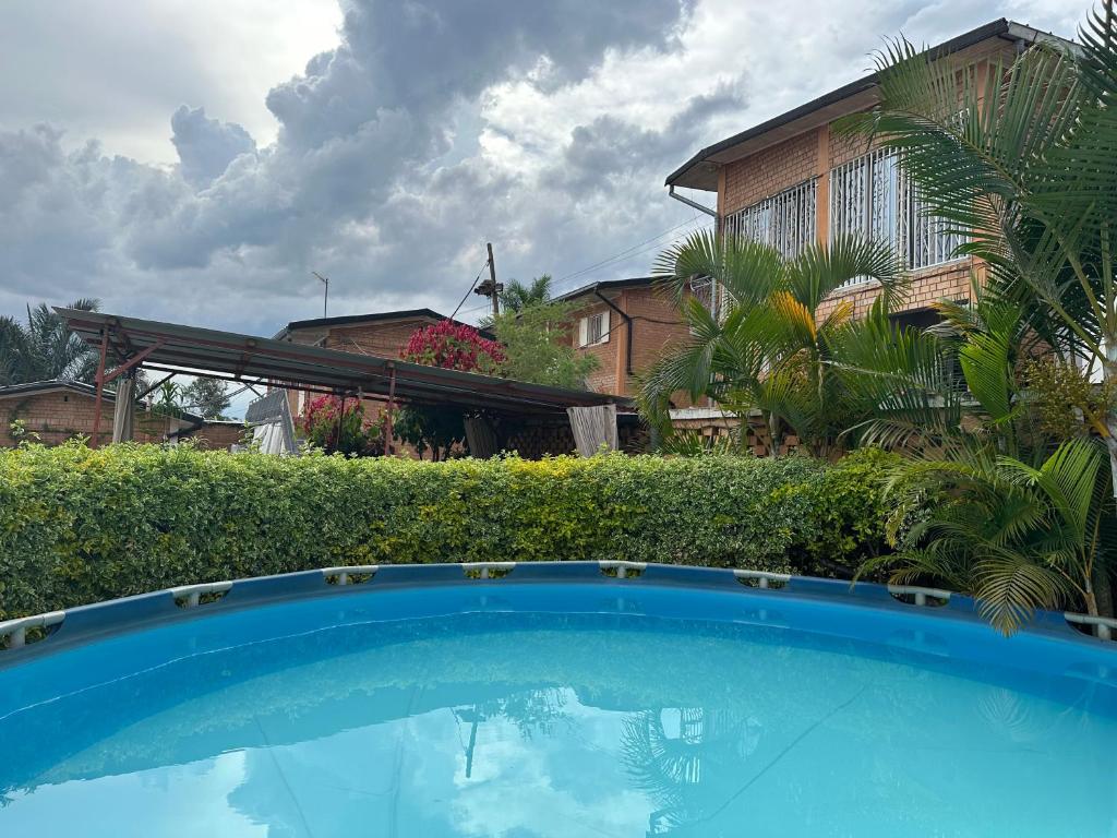 a blue swimming pool in front of a house at Chez Jeanne Auberge Antananarivo in Talata-maty