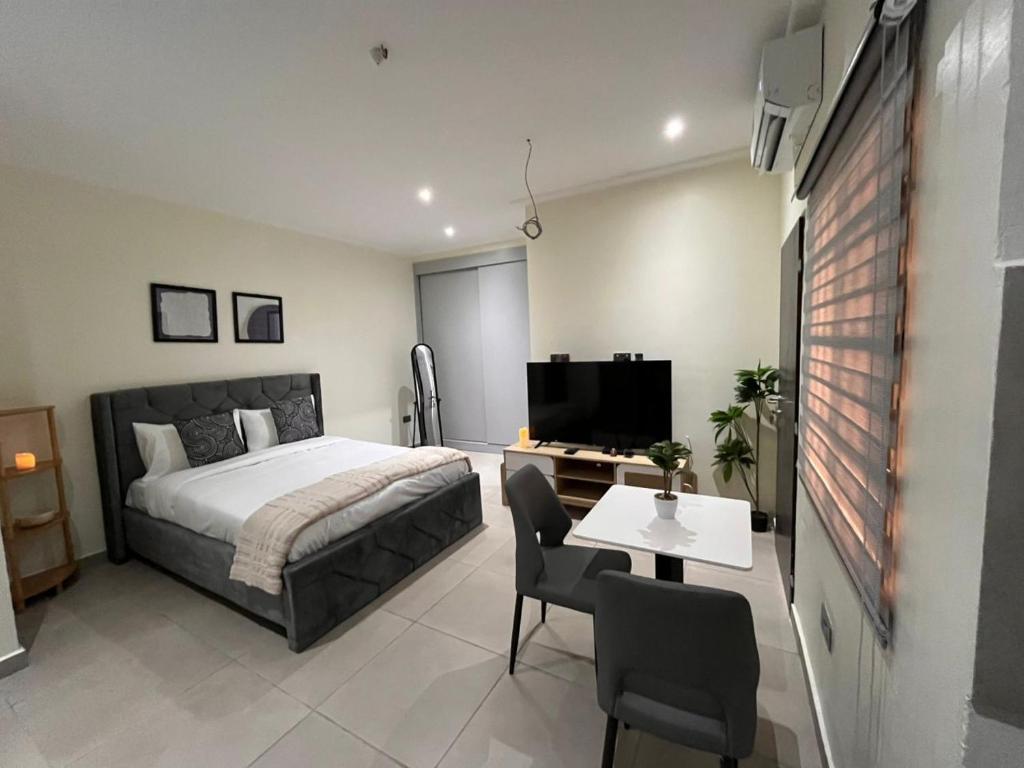 a bedroom with a bed and a table and chairs at Veron, Dzorwulu in Accra