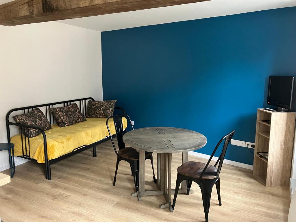 a bedroom with a bed and a table and a tv at Le Balcon in Frazé