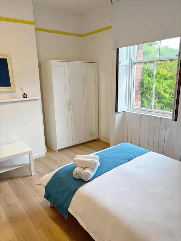 a bedroom with a large bed with towels on it at 13 Frankfield Terrace, Summerhill South, Cork, T12 PY79 in Cork