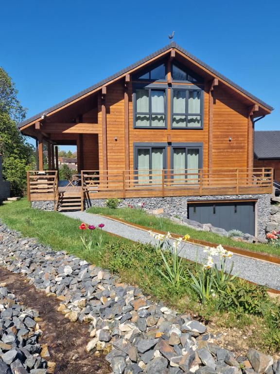 a log cabin with a stone path in front of it at L'edelweiss Normand in Saint-Marcel