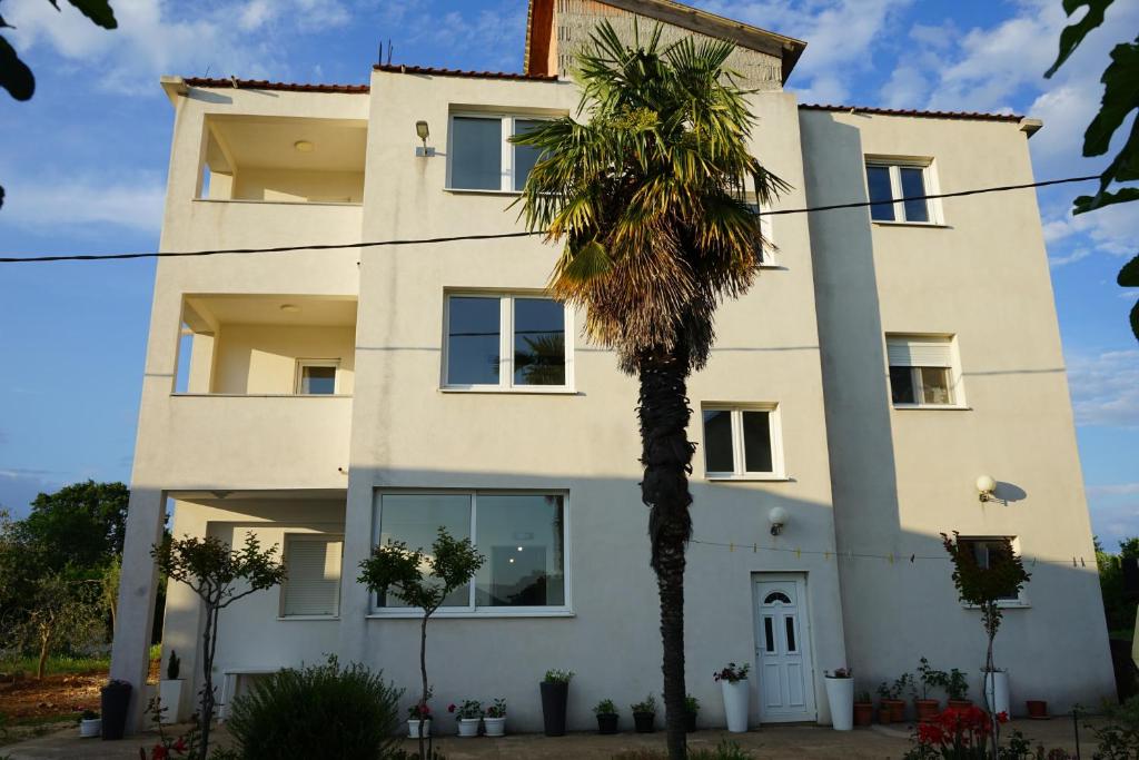 ein Gebäude mit einer Palme davor in der Unterkunft Sobe Soldo in Međugorje