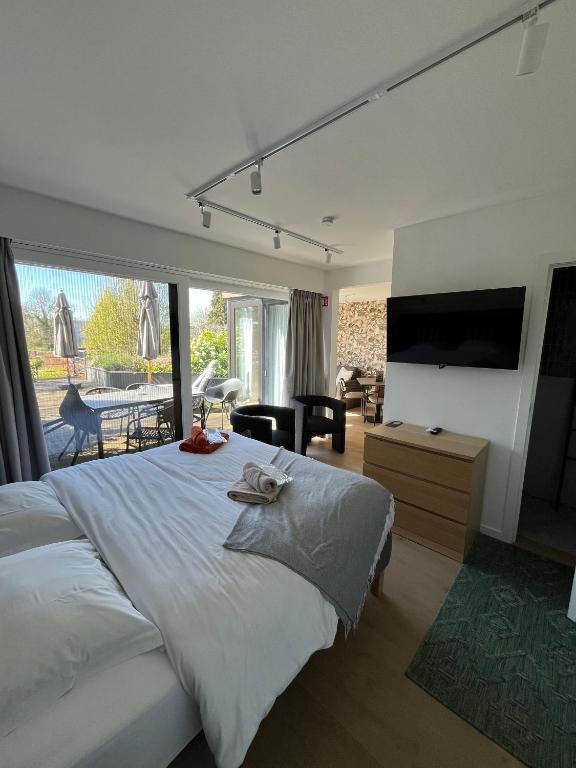 a bedroom with a large bed and a large window at Business Accommodation 'Garden' Living Intimate in Geel