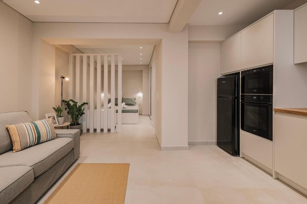 a living room with a couch and a kitchen at The Urban Core at Corfu Center! in Corfu