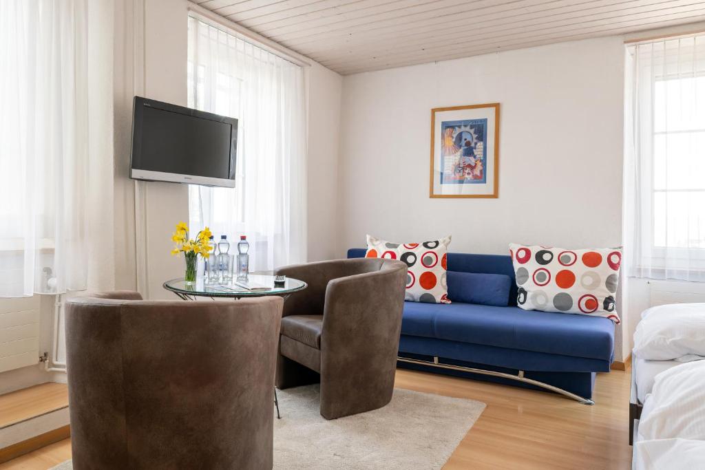 a living room with a blue couch and a table at Hotel Altstadt in Erlach