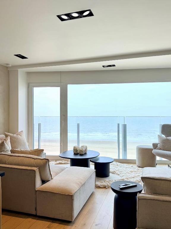 a living room with a view of the ocean at NEPTUNE Wenduine met zeezicht - VOSPROPERTIES in Wenduine