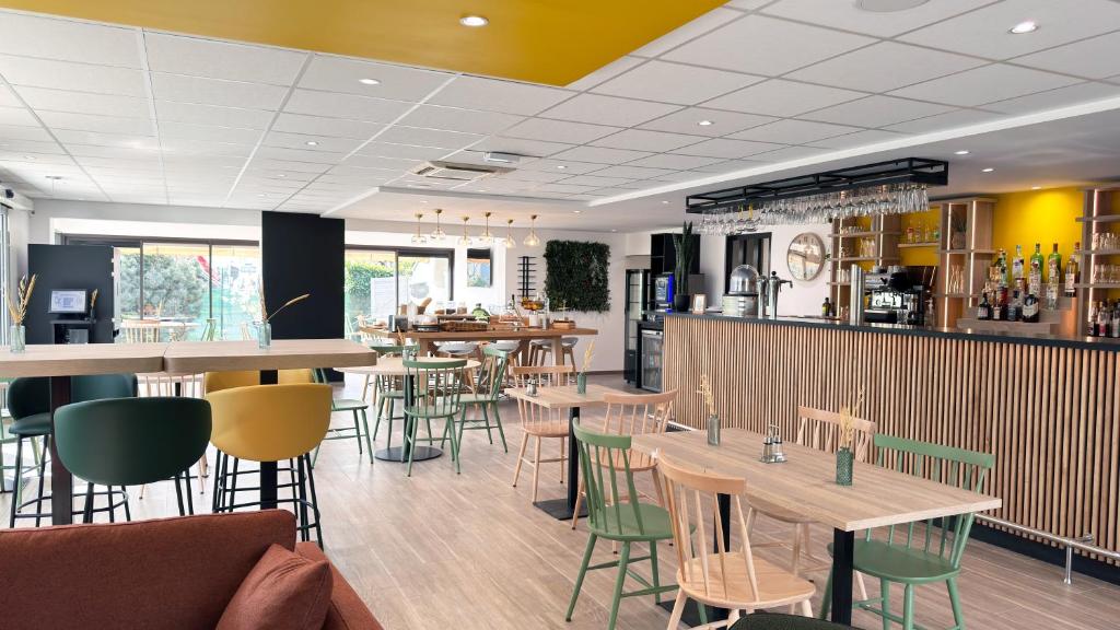 a restaurant with tables and chairs and a bar at Campanile Tours Sud - Chambray-Les-Tours in Chambray-lès-Tours