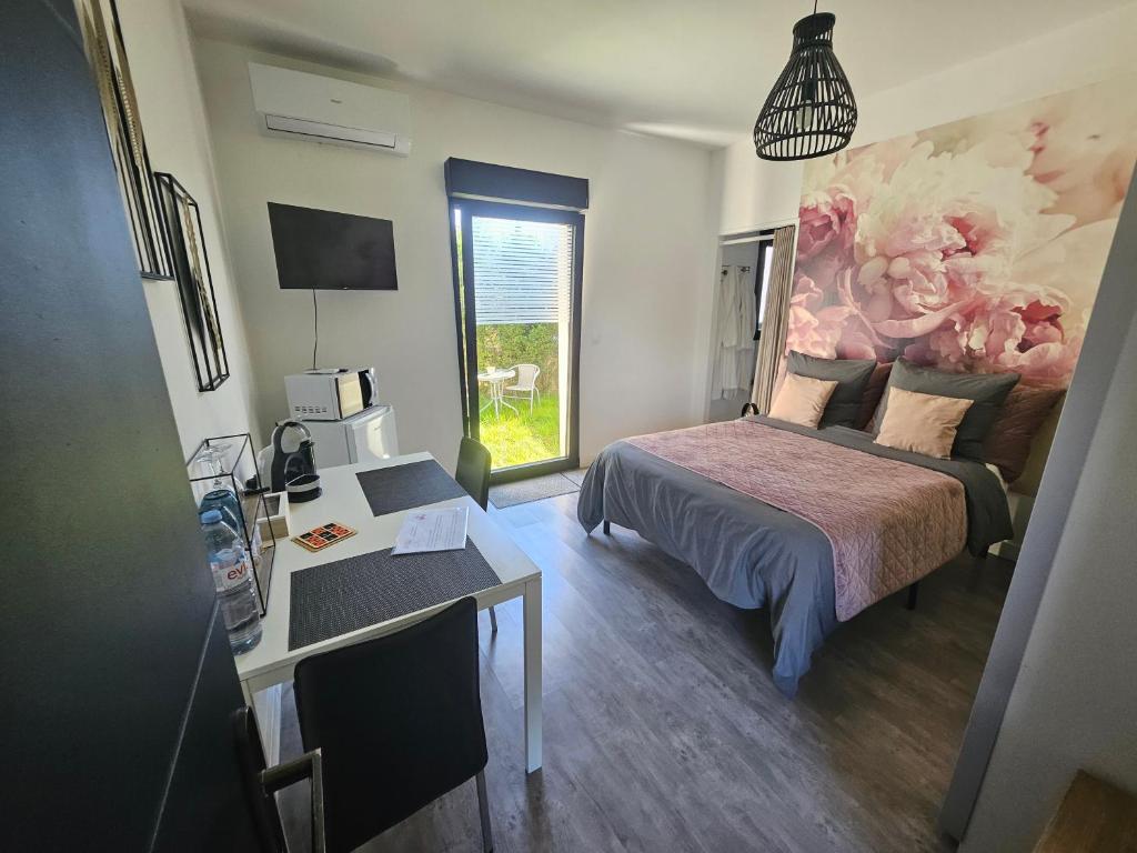 a bedroom with a bed and a desk and a window at Les ateliers in Nivelle