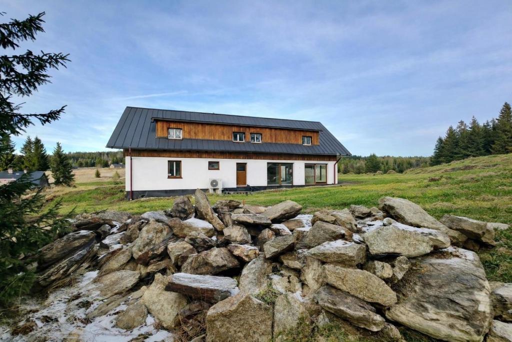 a house on top of a hill with rocks at Pod Lovčí skálou in Modrava