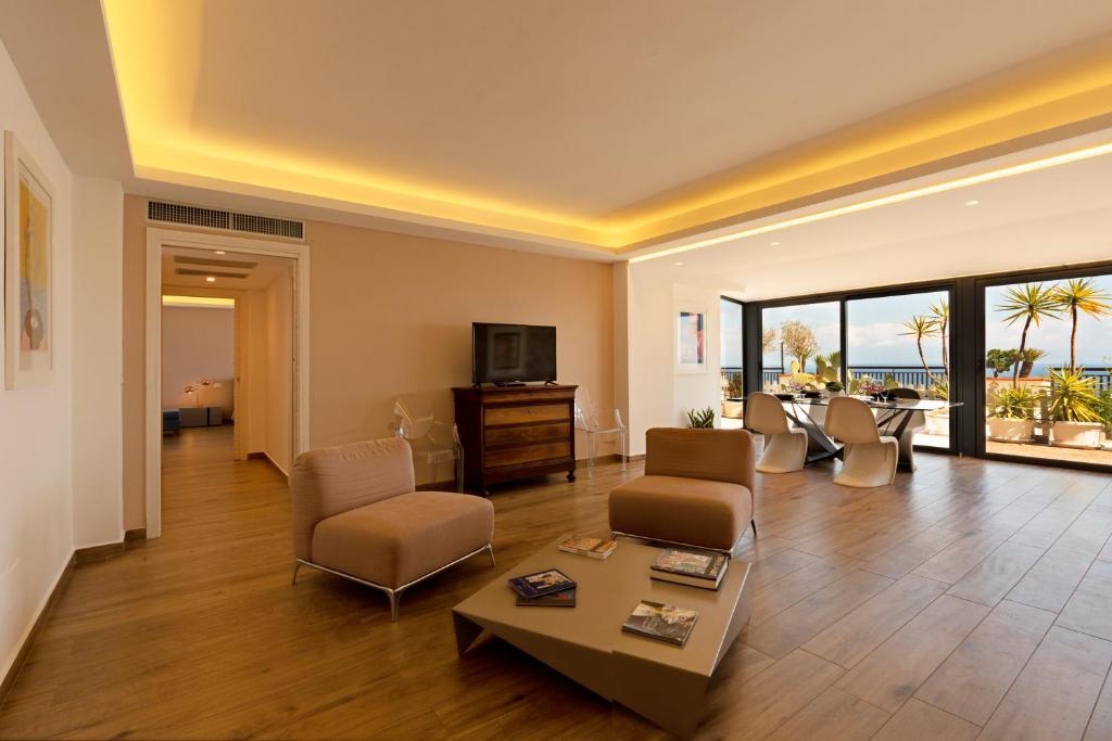 a living room with a couch and chairs and a tv at Maison de Charme Taormina with private jacuzzi in Taormina
