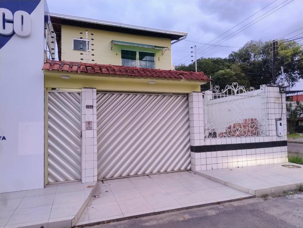 a garage with a gate and a house at Edícula Planalto in Manaus