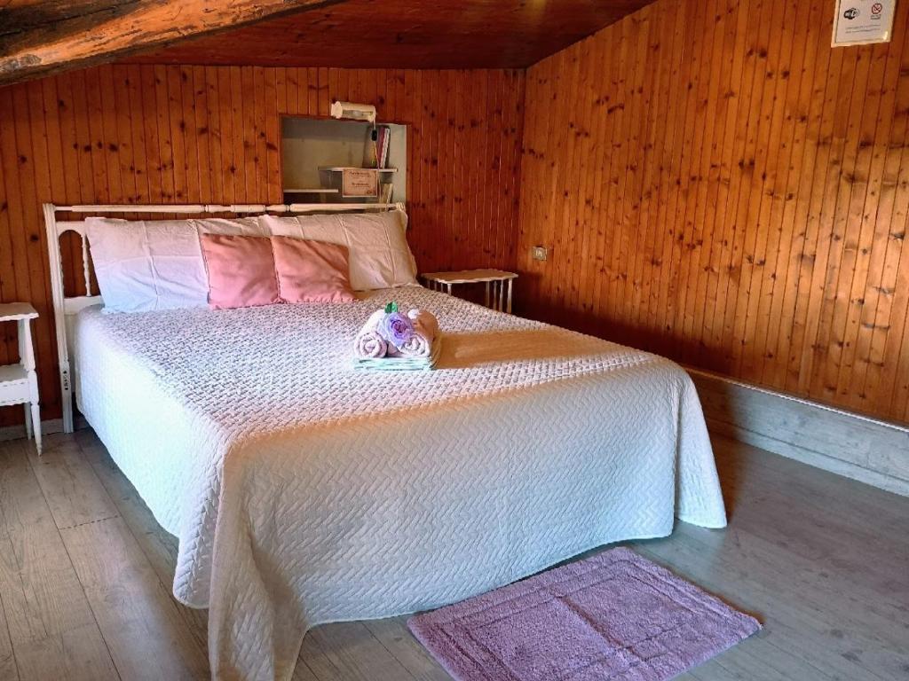a bedroom with a white bed in a wooden room at Affascinante Mansarda nel Cuore di Brunate in Brunate