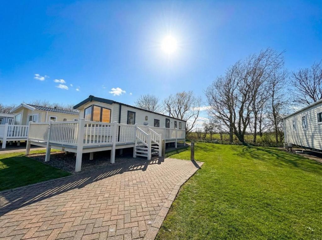 a home with a large yard with a house at Prime lakeside caravan at Haven Golden Sands in Mablethorpe