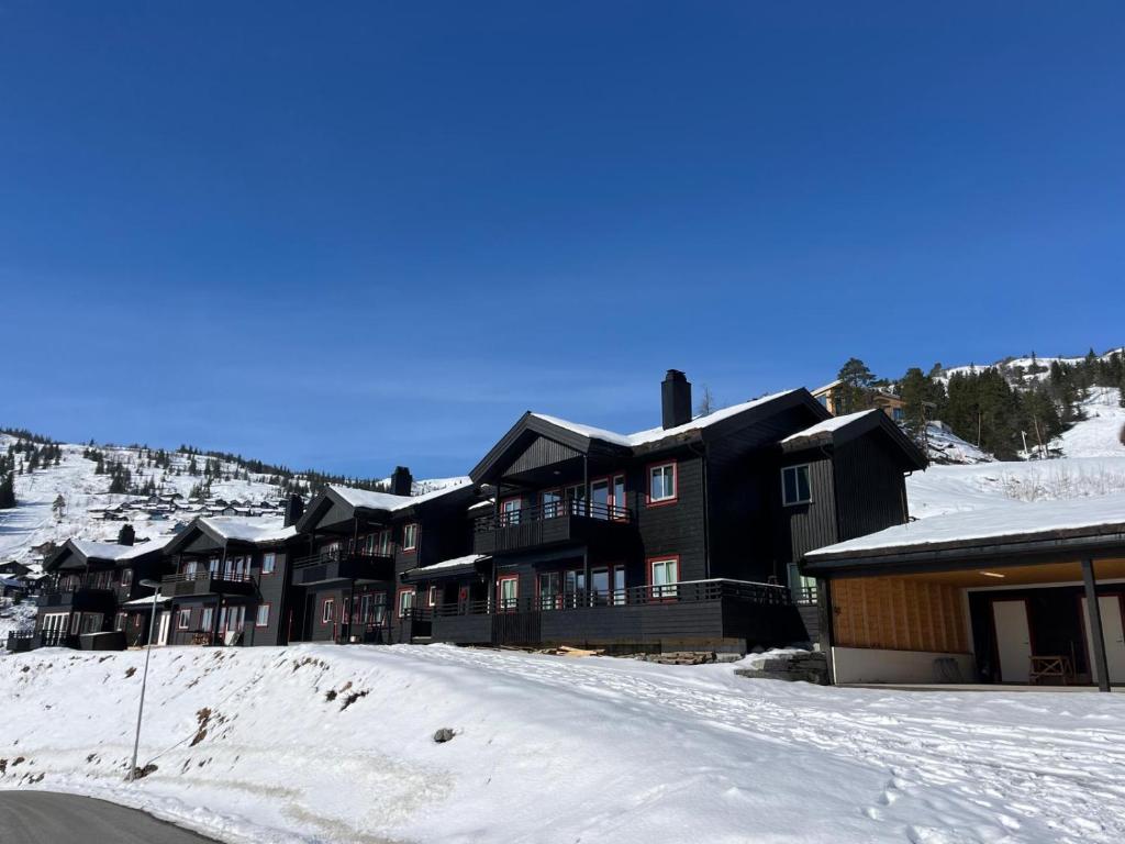 a large building with snow on the ground in front at Sauna & Mountain Views - Ski-in Ski-out Luxury in Vossevangen