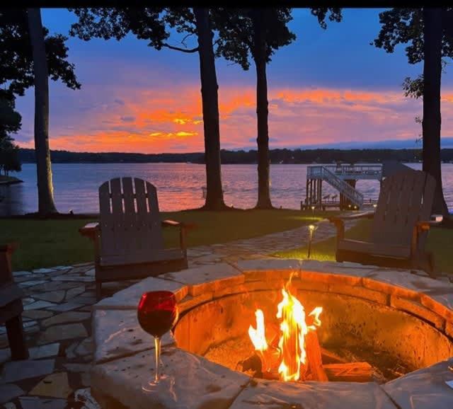 a fire pit with a glass of wine next to the water at Wake N Lake in Littleton