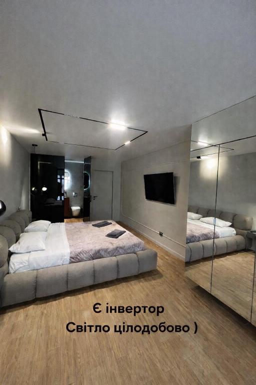 a bedroom with two beds and a large mirror at Перлина Франківська in Ivano-Frankivsk