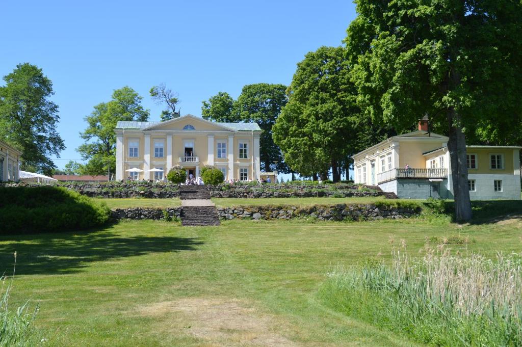 uma grande casa branca com um jardim relvado em Asa Herrgård em Asa