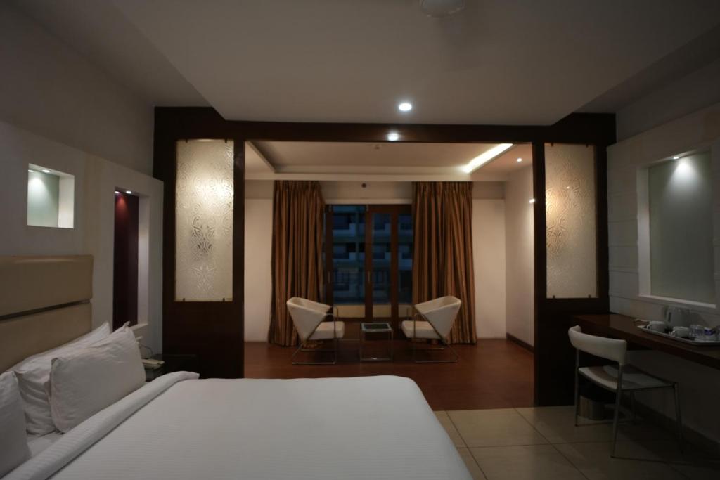 a bedroom with a bed and a table and chairs at Inspira Resort in Silvassa