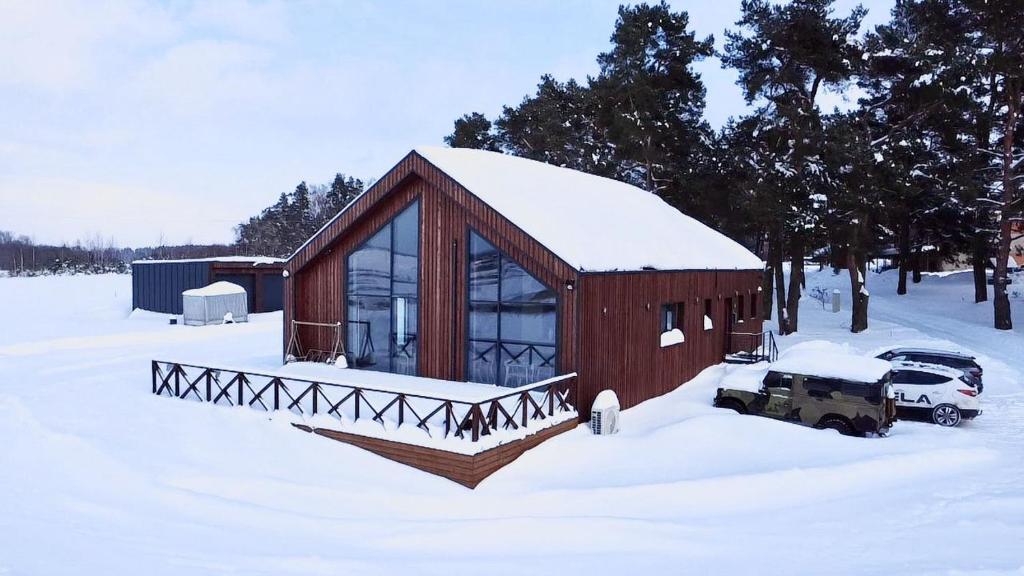 a barn with a truck parked in the snow at Gudelių Kempingas Camp in Gudeliai