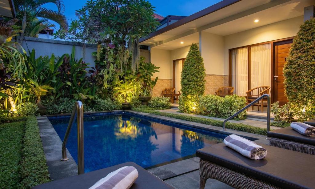 a swimming pool in the backyard of a house at Cening Ayu Sanur in Sanur