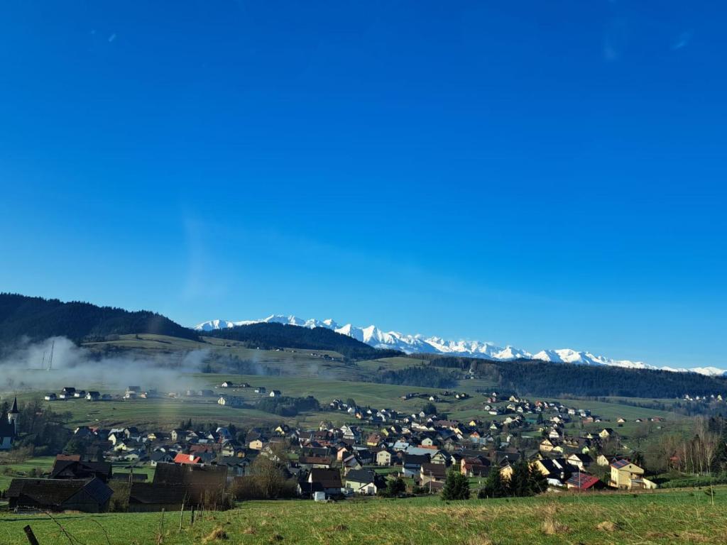 a town in a field with mountains in the background at Słoneczny Domek in Grywałd