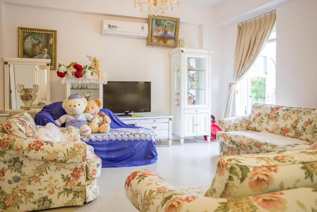 - un salon avec deux chaises et un ours en peluche dans l'établissement Alicegarden Homestay, à Taïtung