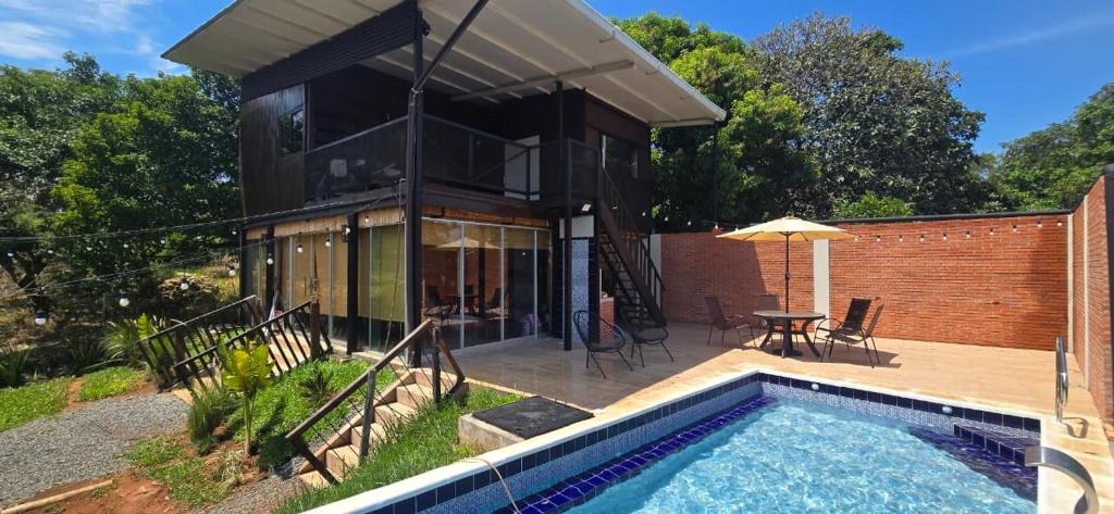 a house with a swimming pool in the backyard at Cabaña con piscina y vista al lago in San Bernardino