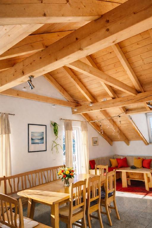 a dining room with wooden ceilings and a table and chairs at Helle Ferienwohnung im Bayerischen Wald mit Balkon, Garten & viel Platz für 4 in Mauth