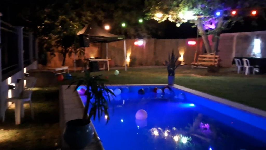 a swimming pool at night with lights in a yard at Casademontaña in Belén