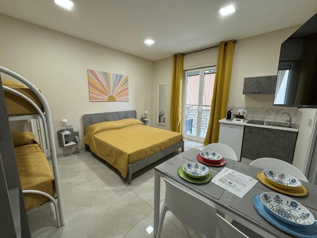 a bedroom with a bed and a kitchen with a table at Rafinù B&B in Ercolano