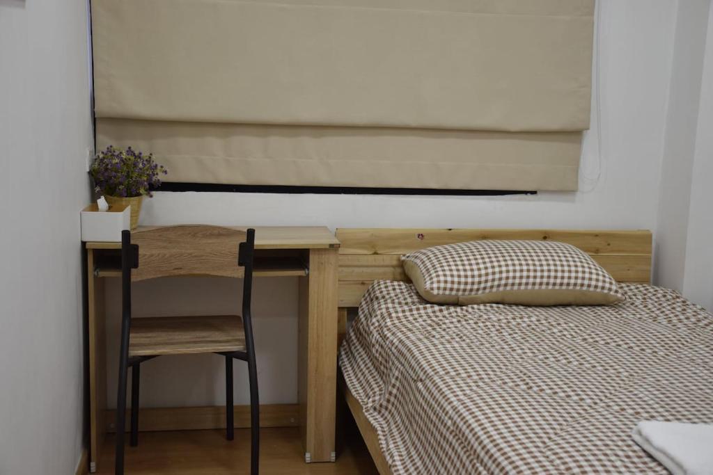 a bedroom with a bed and a table and a chair at alone happy 3 in Ban Khlong Thewa