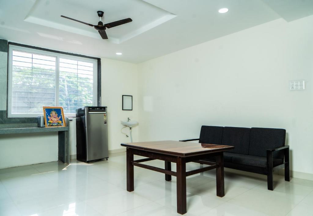 a living room with a table and a chair at Jageshwari Executive in Kolhapur