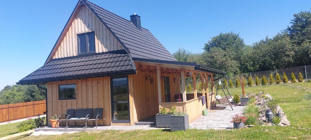 a small wooden house with a gambrel roof at Dębowa Chata in Jasło