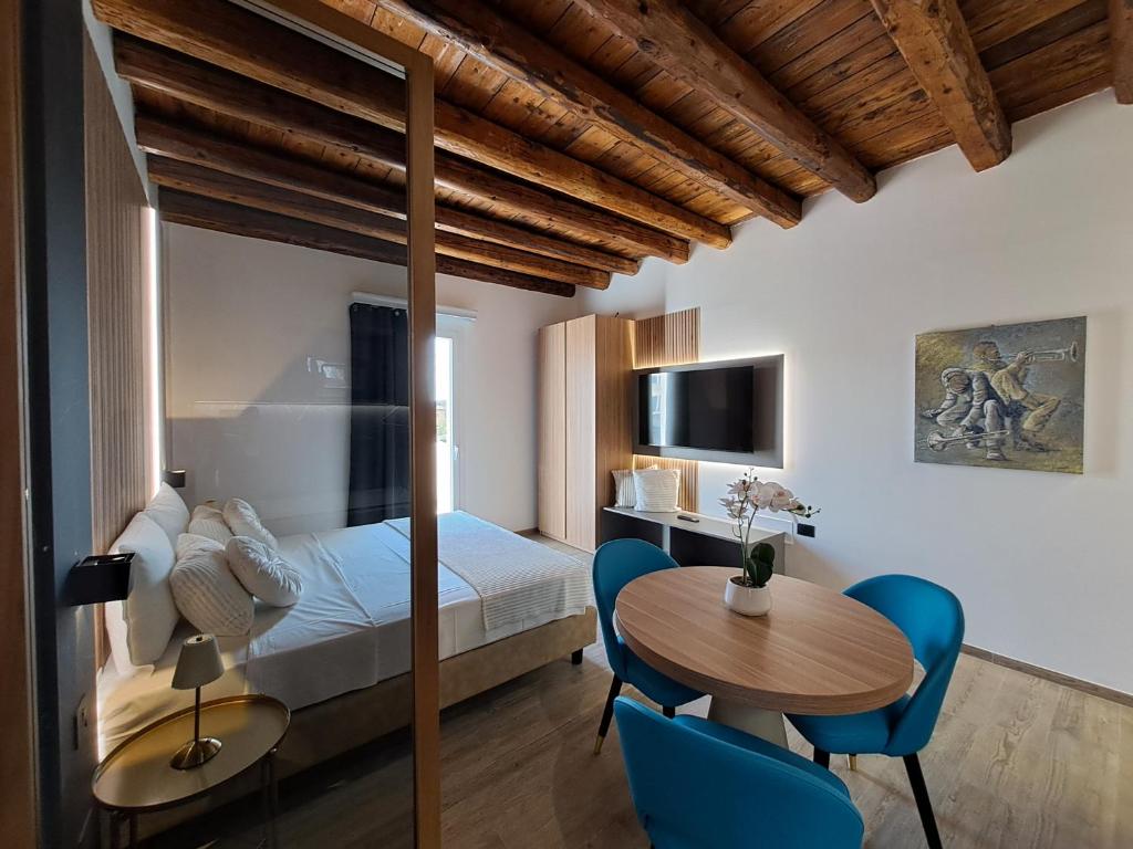 a bedroom with a bed and a table and chairs at Antica Jesolo - M Factory in Jesolo