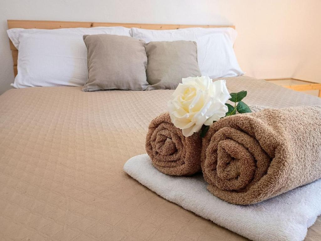 a bed with two towels and a flower on it at Romantic getaway on Lake Como in Brunate