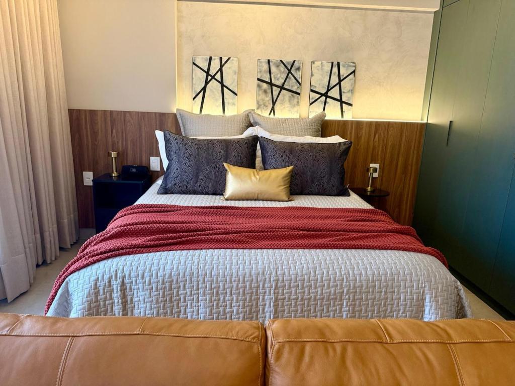 a bedroom with a large bed with pillows at Studio moderno e confortável no Marista in Goiânia