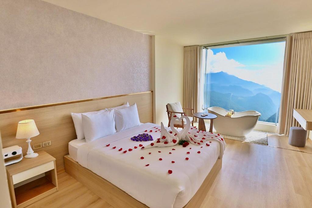 a hotel room with a bed with a tub and a window at Sapa Lumia Hotel in Sapa