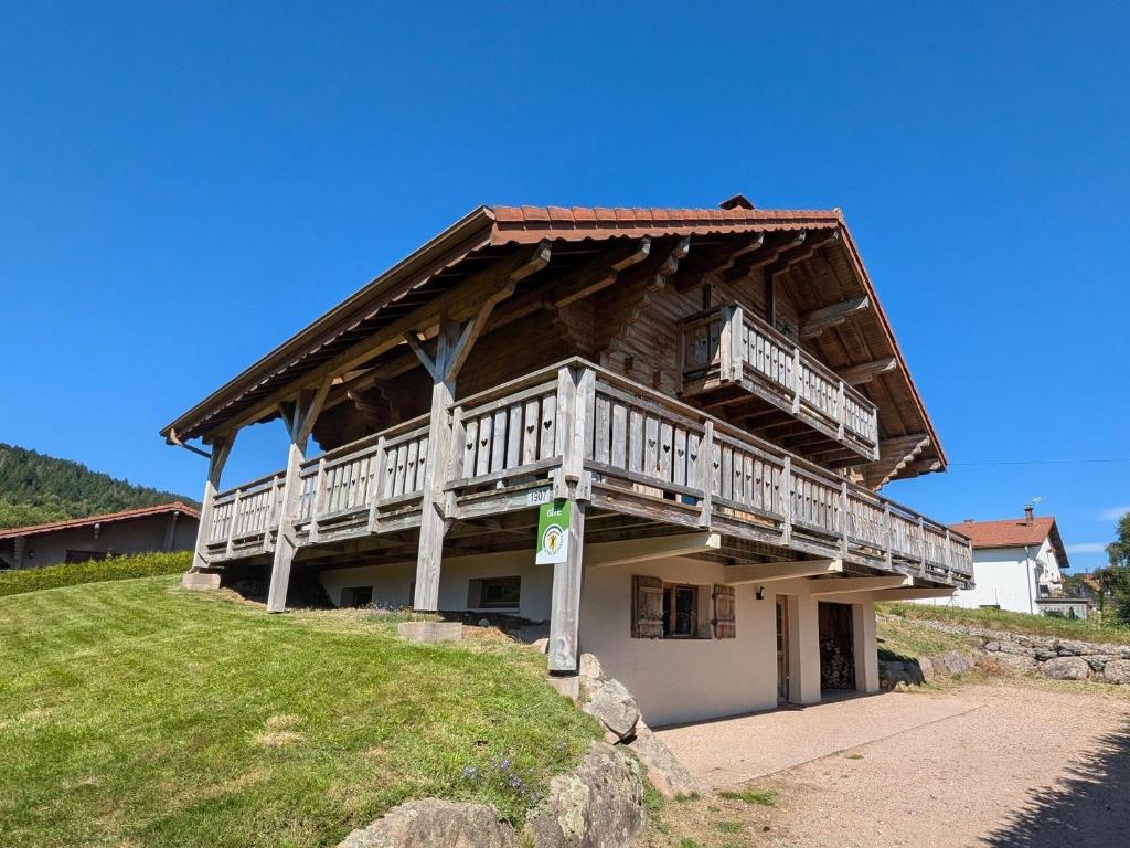 a large wooden house with a balcony on a hill at Chalet Tramontane, gîte tout confort in Xonrupt-Longemer