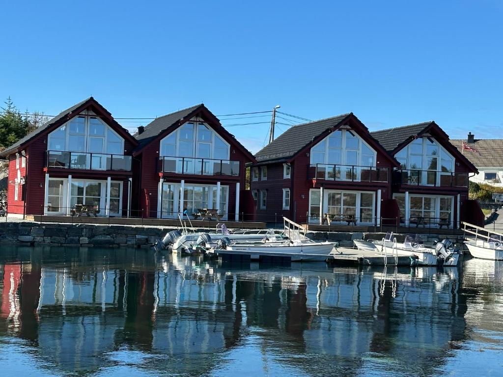 a house on a dock with boats in the water at Heggøy rorbuer in Heggøyni