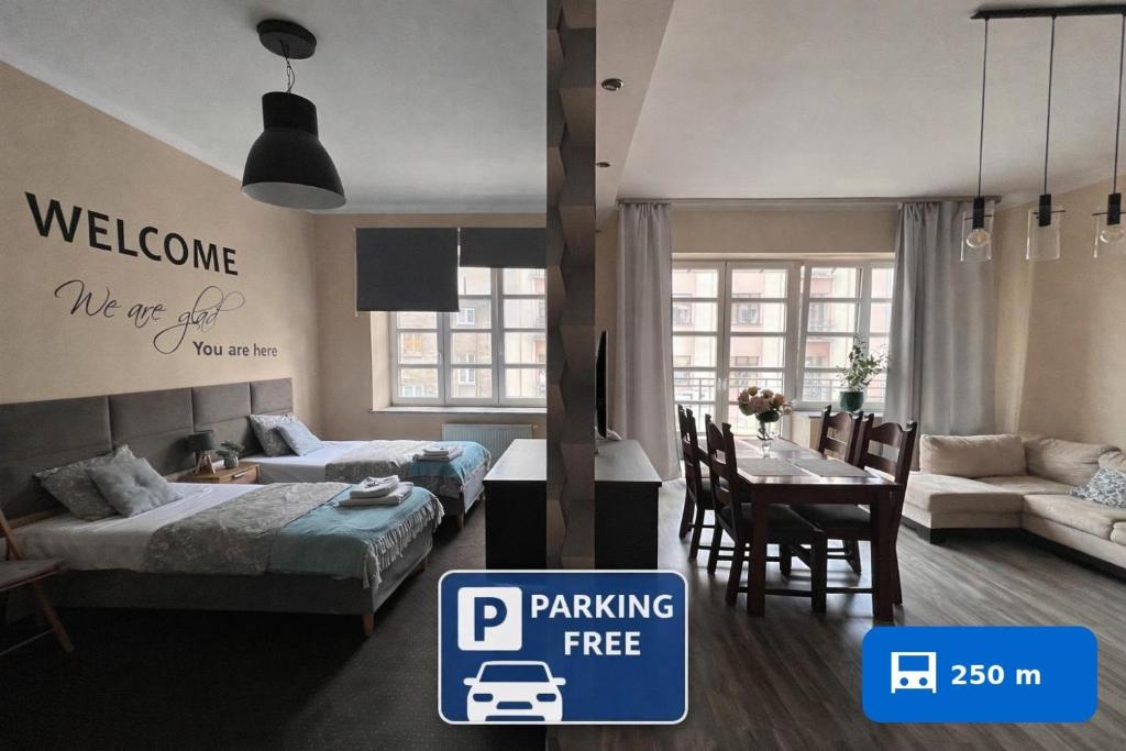 a hotel room with two beds and a dining room at Apartamenty Azzurro in Kielce