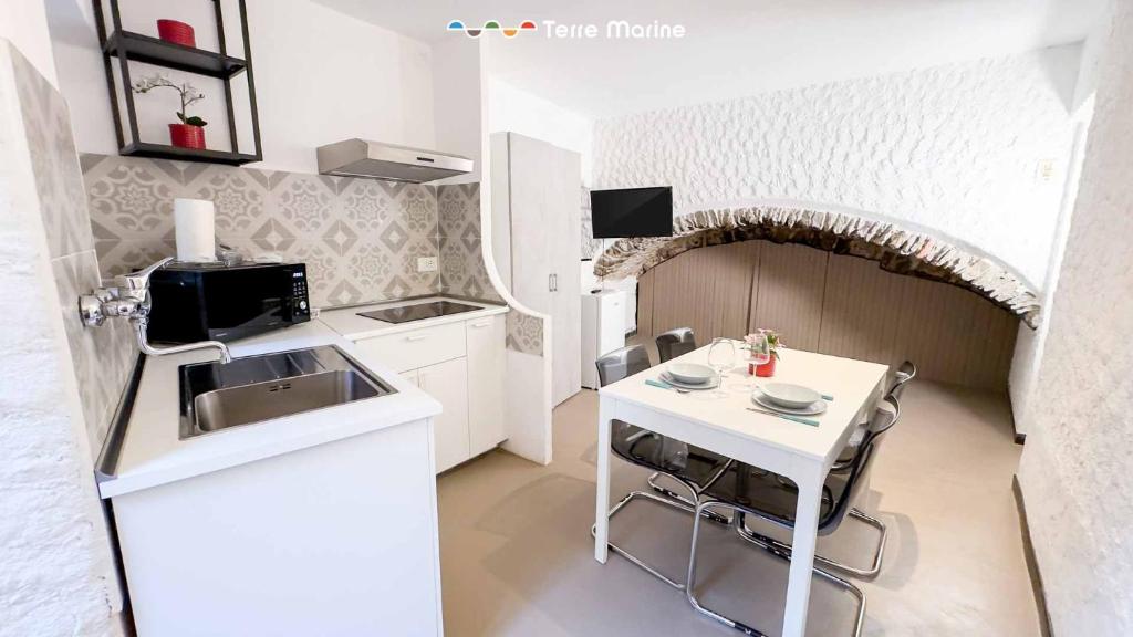a small kitchen with a white table and a sink at La Grotta in Vernazza