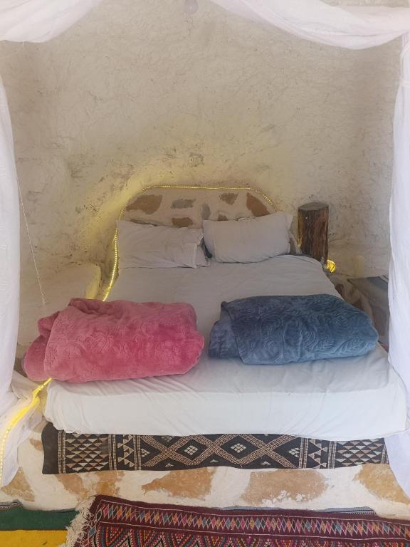 a bed with two pillows on it in a room at Diar twins in Gabès